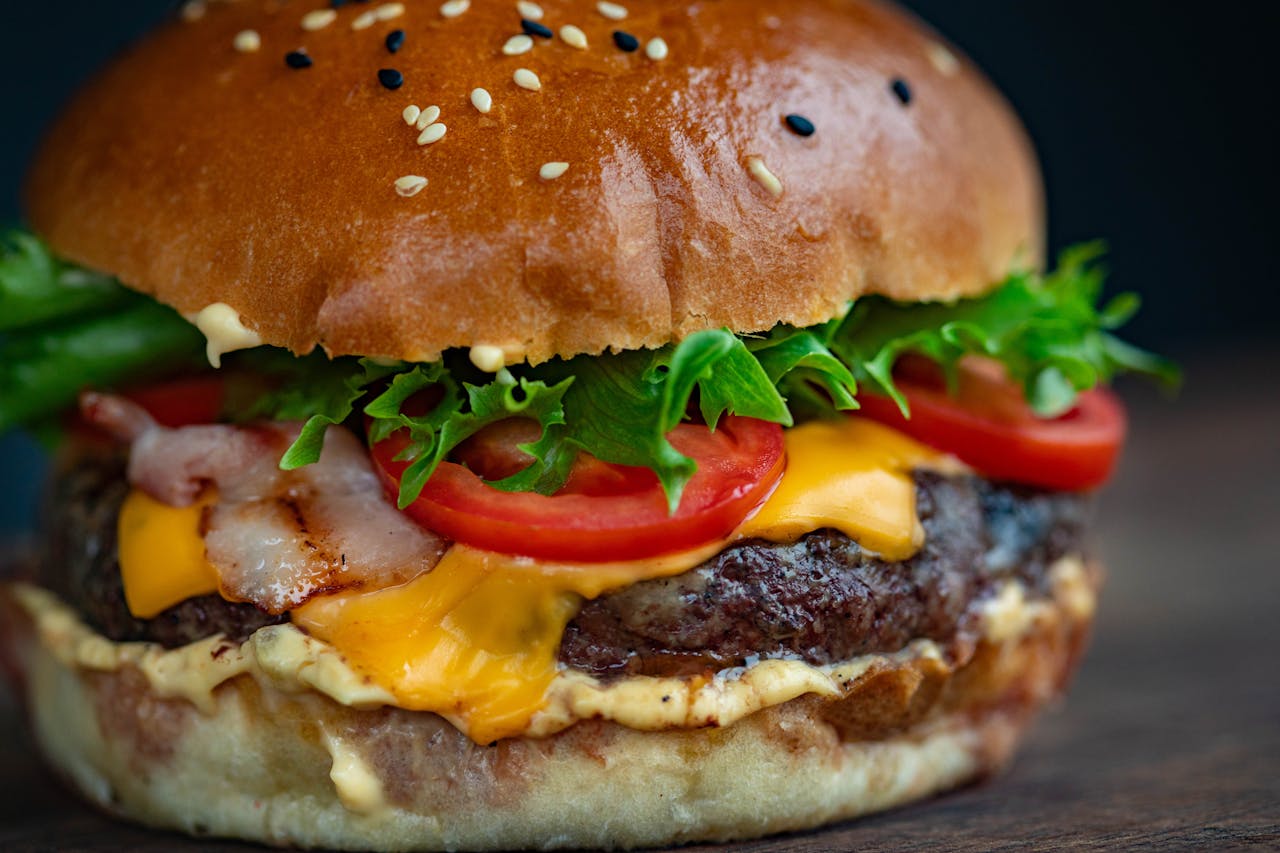 Juicy cheeseburger with bacon, lettuce, tomato, and sesame seed bun.